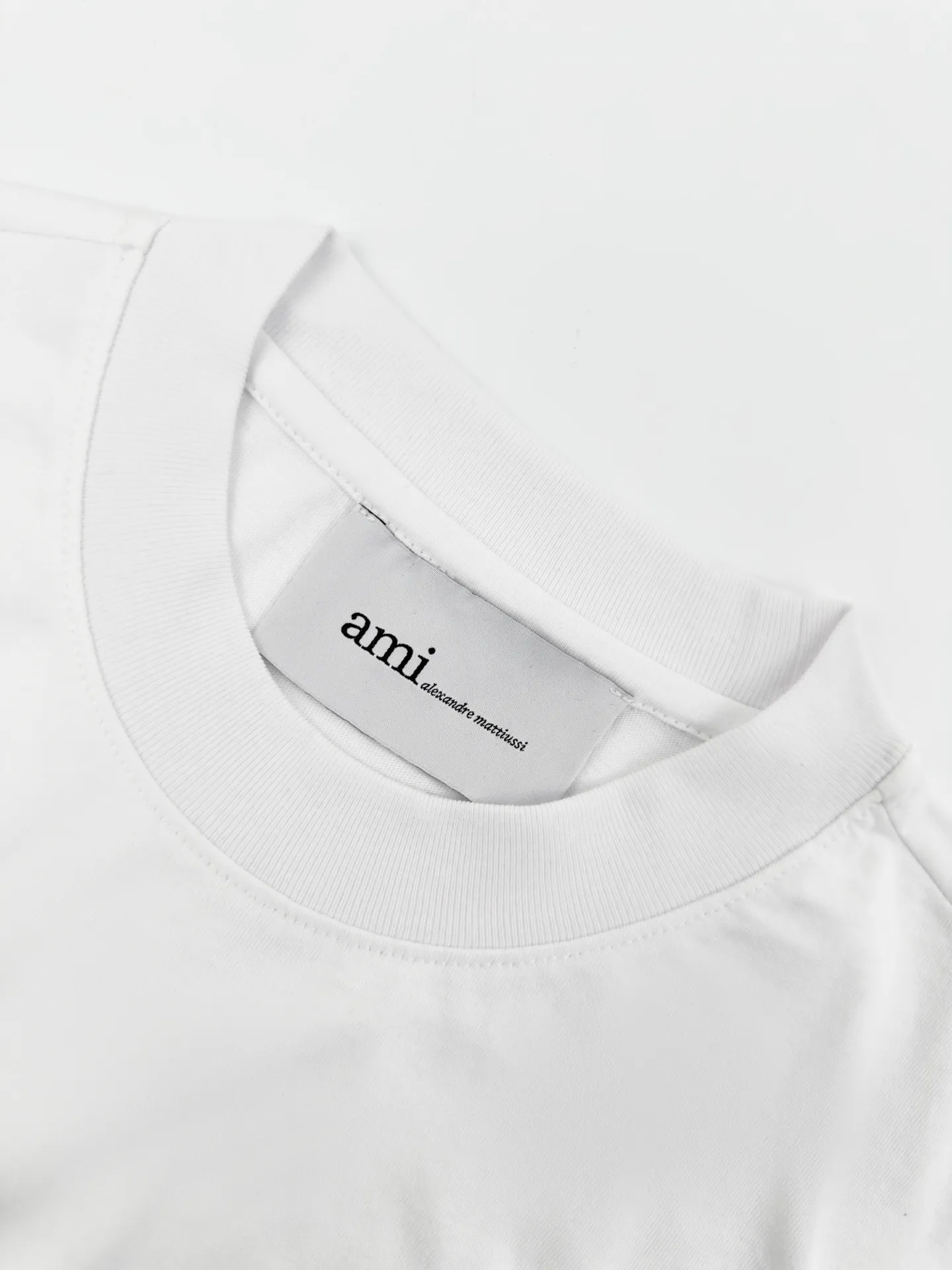 Ami Paris logo embroidered short sleeves. Customized high-count densely spun cotton. Soft and delicate. Comfortable and skin-friendly. Pure white tone like moonlight falling on the body. Extremely restrained colors to demonstrate an effortless sense of luxury. The love logo on the chest is embellished with rough particles. The same color AMI embroidery on the back echoes quietly. French romance is hidden in the details. Low-key but highly recognizable. Use minimalist brushwork to outline a luxurious and relaxing world. Process 1: Use imported machine embroidery technology. Use advanced computer control systems and precision mechanical components to realize Ami logo and letter embroidery operations with high precision and smooth and delicate lines. Process 2: The fabrics have been fermented and washed for better hand feel. Not easy to deform, not easy to shrink, not easy to fade, and maintain long-term beauty. Accessories: Customized 1:1 Ami trademark. Version: Loose version. Size: S M L XL. Style number: BB 820.